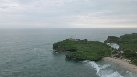 Aerial-view-of-fish-monument-on-the-huge-coral-rock-on-Krakal-Beach