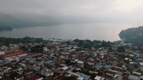 Aerial:-Slow-orbit-shot-of-San-Juan-La-Laguna-village-in-Lake-Atitlan,-Guatemala-during-a-cloudy-day