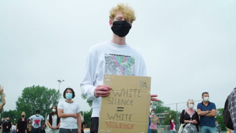 Blonde-teenager-turning-around-protest-sign-during-silent-rally-for-black-lives-matter
