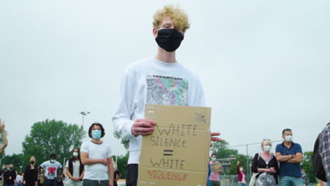 Adolescente-Rubia-Dando-La-Vuelta-Al-Cartel-De-Protesta-Durante-Una-Manifestación-Silenciosa-Por-Las-Vidas-De-Los-Negros-Importan