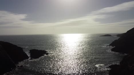 Aerial-Wide-View-of-Calm-Ocean-on-Sunny-Day-with-Dramatic-Coastline