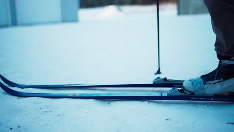 Skier's-Feet-In-Ski-Boots-Clipping-Into-Ski-Bindings-On-Snow