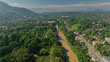 Peradeniya-Sri-Lanka-Aerial-v1-drone-fly-along-Mahaweli-river-capturing-royal-botanical-garden,-university-campus,-A1-road-bridge-and-Kandy-hillside-suburbs---Shot-with-Mavic-3-Cine---April-2023