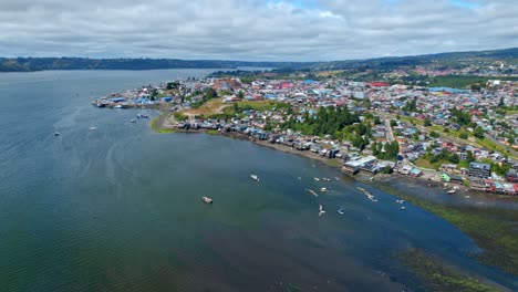 Aerial-panoramic-landscape-of-chiloé-island-patagonia-chile-travel-sea-destination-blue-holiday-village-on-top-of-green-summer-hills,-establishing-drone