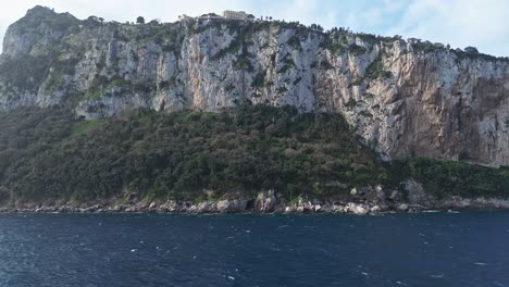 Majestuosos-Acantilados-De-Capri,-Italia-Con-Vistas-Al-Mar-Azul,-Belleza-Natural-En-Un-Día-Soleado,-Plano-Amplio