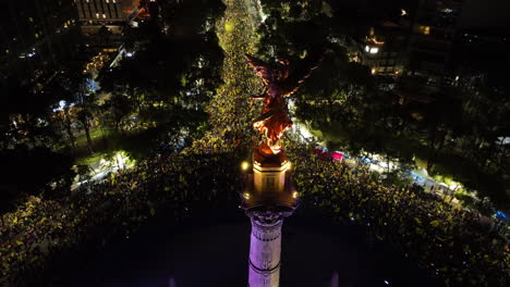 Aerial-view-circling-the-El-Ángel-statue,-soccer-champion-celebrations-in-CDMX