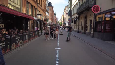 People-move-around-on-a-pedestrian-street-in-central-Stockholm,-Sweden