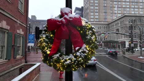 Christmas-wreath-on-city-street-lamp-post-during-snow-flurries