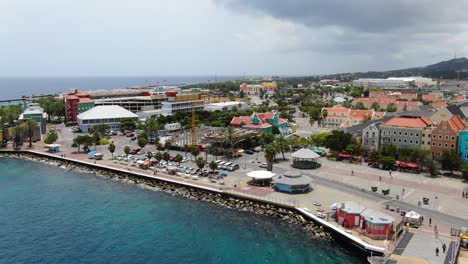 Pan-across-promenade-on-sunny-day-as-tourists-roam-vibrant-city-of-Willemstad-Curacao
