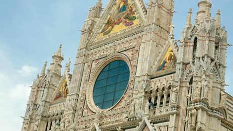 Slow-tilt-up-of-the-façade-of-the-Siena-Cathedral,-a-medieval-church-in-Siena,-Italy