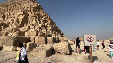 Tourists-posing-in-front-of-the-Great-Pyramid-of-Giza-on-a-clear-day