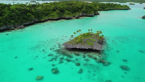 Cinematic-drone-flight-around-remote-rocky-island-in-Fiji-surrounded-by-natural-lagoon
