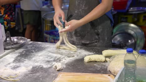 Un-Cocinero-Haciendo-Masa-Para-Fideos-De-Comida-Callejera-Sobre-Una-Mesa-Cubierta-De-Harina-En-Kuala-Lumpur