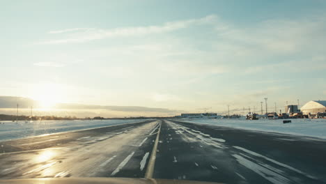 Flughafen-Inspektionsfahrzeug-Fährt-Im-Wintersonnenuntergang-Auf-Verschneitem-Rollweg-Voller-Eis