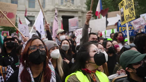 A-Crowd-of-Pro-Palestine-Protestors-Cheer-and-Shake-Their-Fists-in-the-Air-in-a-Large-Crowd,-wide-shot