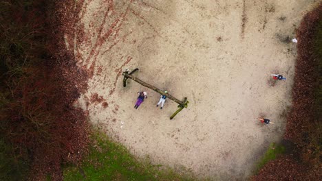 Kids-swinging-drone-top-down-vertigo-orbit-view-in-children-playground