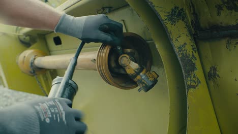 Close-up-of-hands-changing-a-car-tire-with-tools,-focus-on-mechanical-work