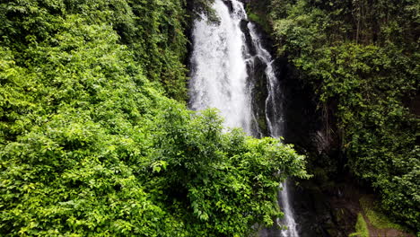 Lush-green-foliage-surrounds-a-cascading-waterfall-in-Banos,-Ecuador