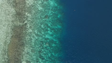 Aerial-top-down-view-above-vertical-gradient-sea-shore-skyline-water-clean-reflected-with-turquoise-golden-yellow-marine-tones,-beach-sand-white-southeast-asian-travel
