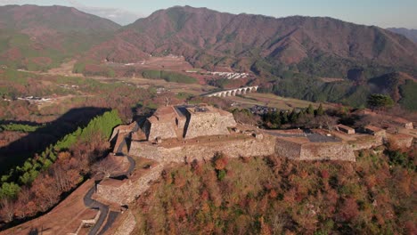 Panoramadrohne-über-Den-Ruinen-Einer-Alten-Zivilisation-Im-Bergtal-Takeda-Castle,-Japanische-Präfektur-Hyogo,-Asago-Bei-Morgensonne