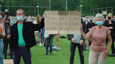 Pareja-De-Ancianos-Sosteniendo-Un-Cartel-De-Protesta-Durante-Una-Manifestación-Pacífica-En-Los-Países-Bajos,-Protesta-Por-El-Movimiento-Black-Lives-Matter