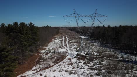 Backward-aerial-shot-of-pylones-in-a-field-during-the-day