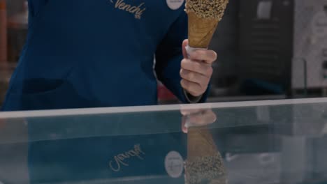 Artisan-scooping-nut-coated-gelato-in-Venice-shop