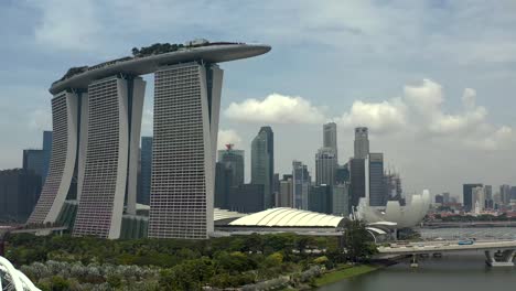 Toma-Panorámica-Del-Hotel-Marina-Bay-Sands-Con-Fondo-De-La-Ciudad-A-Través-Del-Puerto-De-Singapur