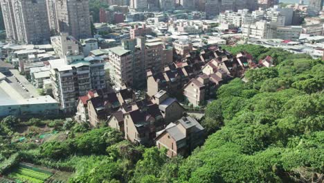 Zhuwei,-Taipei,-showcasing-the-contrast-between-lush-greenery-and-urban-architecture,-Aerial