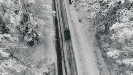 Imágenes-De-Drones-De-Un-Automóvil-Conduciendo-En-El-Camino-Forestal-De-Invierno