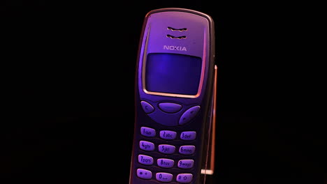 Vintage-Nokia-3210-Tastatur-Mobiltelefon-Auf-Rotierendem-Display-Mit-Schwarzem-Hintergrund-In-Nahaufnahme