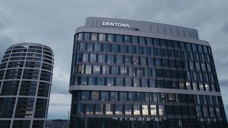 Aerial-drone-view-of-modern-office-business-building-with-big-windows-at-dusk