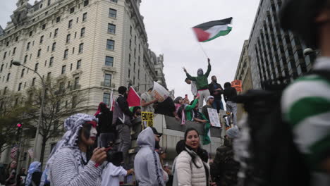 Manifestantes-Pro-Palestinos-Ondeando-Banderas-Y-Vitoreando-En-Un-Camión-En-Medio-De-La-Calle