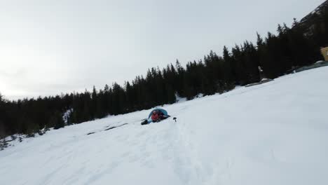 FPV-drone-flies-in-dizzy-orbit-around-winter-campers-with-scenic-lake-and-mountains