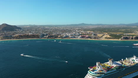 Drohnenschuss-über-Einem-Kreuzfahrtschiff-Und-Booten-An-Der-Küste-Von-Cabo-San-Lucas,-Mexiko