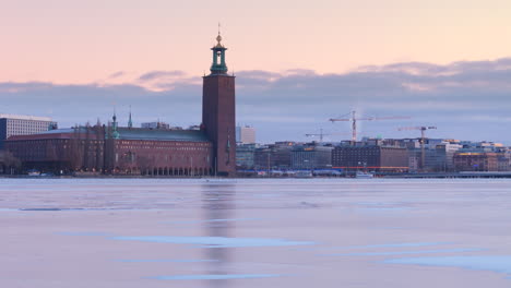 Luftaufnahme-über-Dem-Vereisten-Riddarfjärden-Mit-Blick-Auf-Das-Stockholmer-Rathaus-Im-Abendhimmel