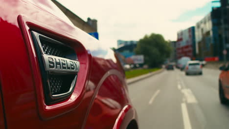 Nahaufnahme-Des-Shelby-Logos-Auf-Einem-Kirschroten-Ford-Super-Snake-Aus-Dem-Jahr-2018,-Der-Auf-Einer-Autobahn-In-Estland-Fährt