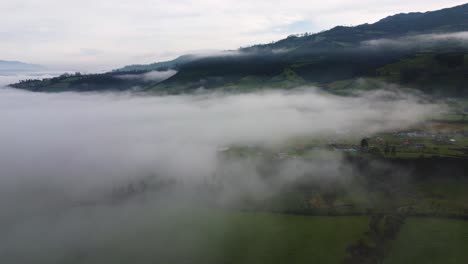 Dron-Cinematográfico-Paralelo-Sobre-El-Clip-Aéreo-Clous-Sobre-Campos-Brumosos-En-Neblina,-Machachi,-Ecuador