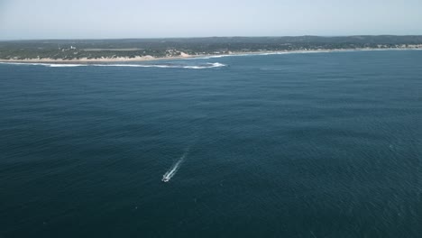 Toma-Aérea-Alta-De-Un-Barco-Que-Se-Dirige-Al-Mar-Desde-La-Costa-De-Mozambique