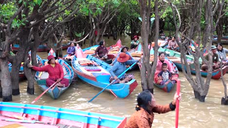 Los-Aldeanos-Están-Sentados-En-Sus-Modestos-Barcos-Tradicionales,-Esperando-Ansiosamente-Que-Los-Turistas-Se-Unan-A-Ellos-Para-Un-Viaje-Sereno-A-Través-Del-Bosque-Del-Lago-De-Kampong-Phlukvillage.