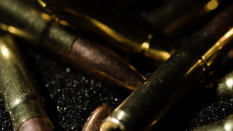 Macro-detail-closeup-of-300-AAC-Blackout-bullets-on-gunpowder-dust,-circle-pan