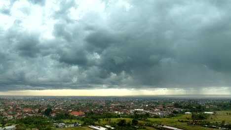 Storm-clouds-roll-in-over-Bali-countryside,-aerial-hyperlapse-view