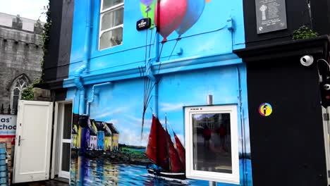 Street-art-mural-in-Galway-on-Shop-Street,-colorful-balloons-and-boat