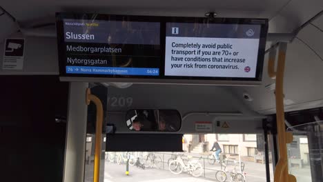 Covid-virus-info-in-English-on-screen-in-city-bus-in-Stockholm,-Sweden