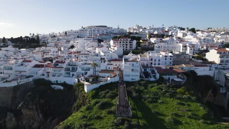 Panoramic-Aerial-Establishing-Overview-of-White-Walled-Luxury-Home-Buildings-on-Cliffs-of-Albufeira-Portugal-Looking-over-Ocean