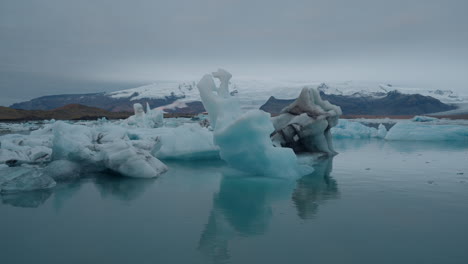 Glacier-Lagoon,-Jökulsárlón,-Iceland,-with-icebergs-and-flowing-icy-blue-water