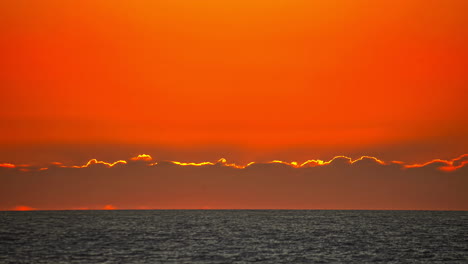 Timelapse-Del-Amanecer-Rojo-Sobre-El-Mar-Desde-Detrás-De-La-Nube-Con-Teleobjetivo-De-Cerca