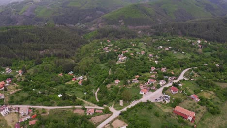 REtreating-drone-shot-of-the-village-of-Tsarichina,-a-place-known-for-military-excavations-and-strange-paranormal-activities-in-Bulgaria