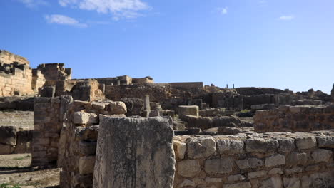 Sunlit-ancient-Roman-ruins-in-Dougga-against-a-clear-blue-sky