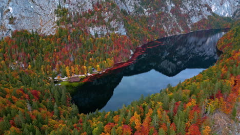 Crystal-clear-lake-Toplitz-below-mountain-cliffs-and-autumn-forests